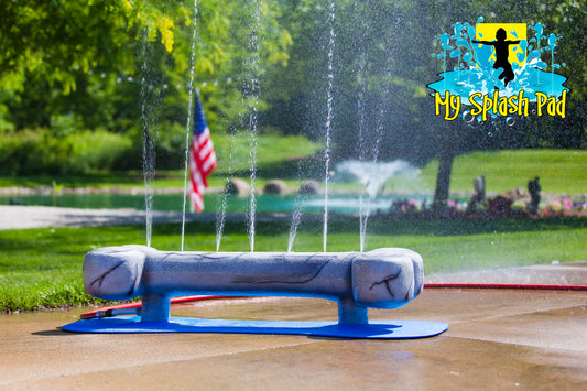 Dog Bone Water Play Feature by My Portable Splash Pad – large sculpted gray dog bone on a blue base with vertical spray jets creating a fun splash zone for dogs.