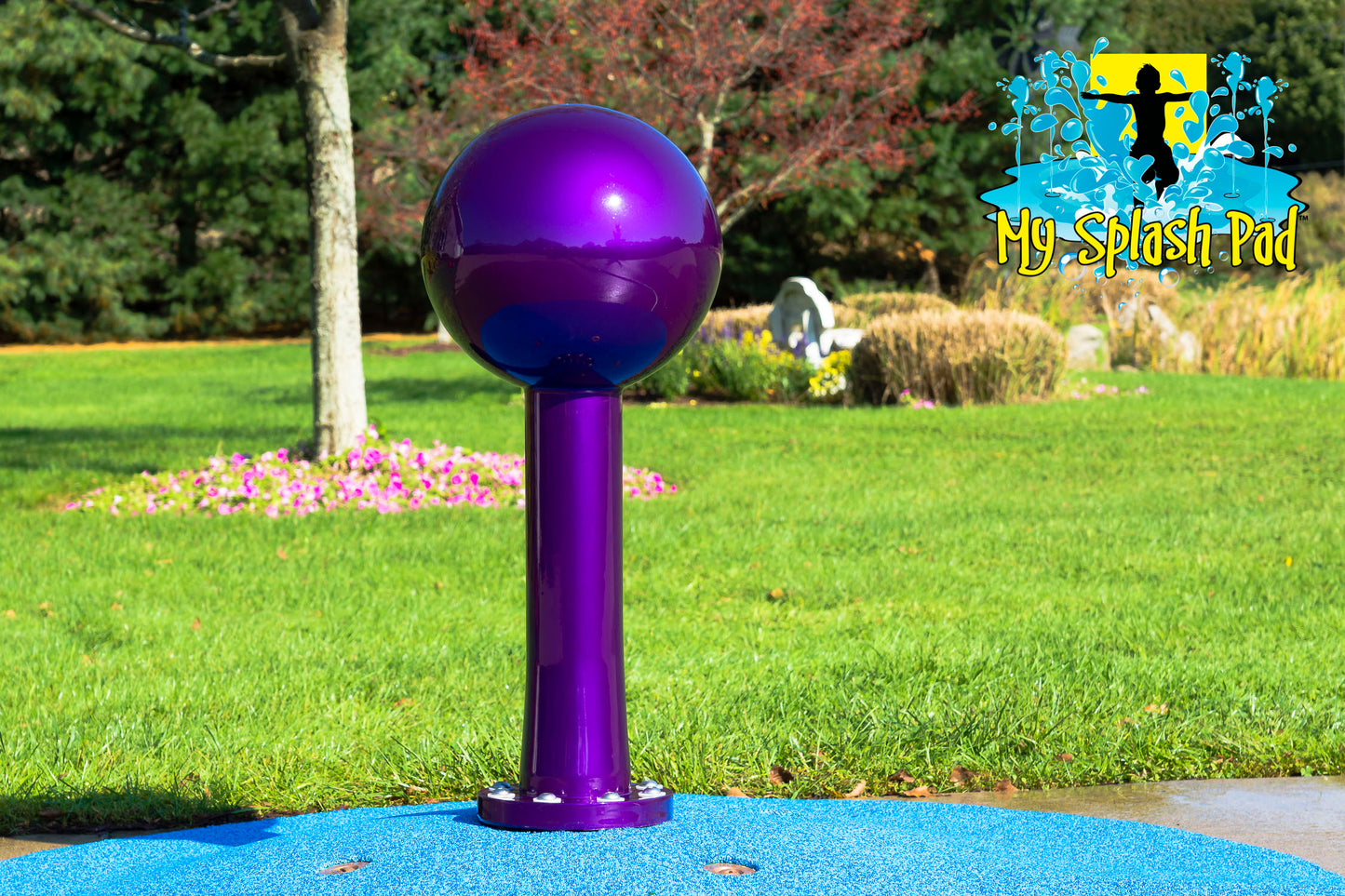 Purple Lollipop Portable Splash Pad Water Play Feature standing tall on blue safety surfacing in backyard setting.