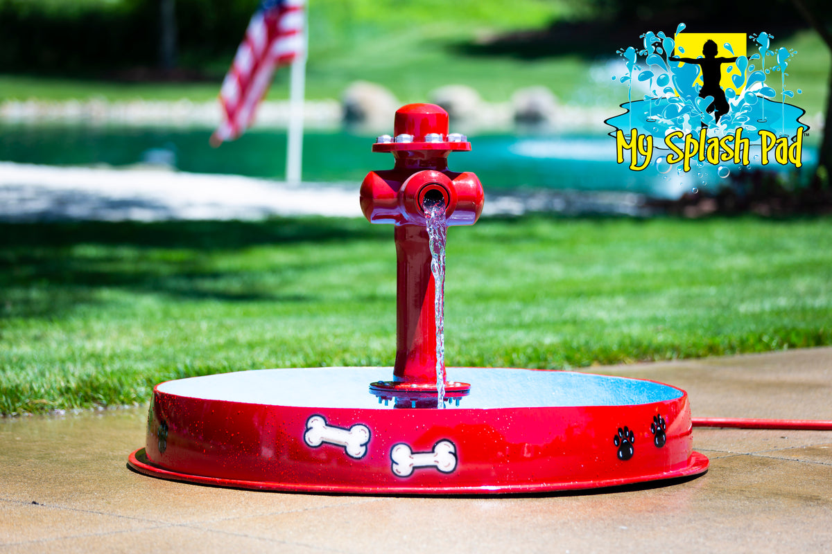 A red dog bowl with a hydrant-style water play feature, designed for outdoor water games by My portable splash pad.
