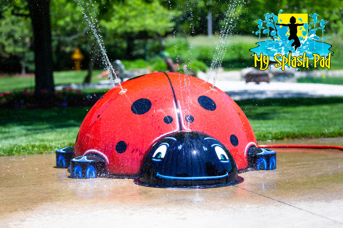Large Ladybug Mobile Spray and Play Feature by My Splash Pad – red and black ladybug water play structure spraying streams of water outdoors.