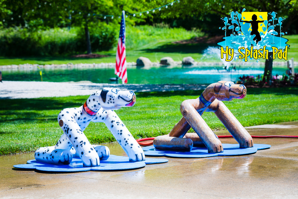Sitting Dog Mobile Water Play Features by My portable splash pad. Trees and grass in the background. Sunny day in Ohio.