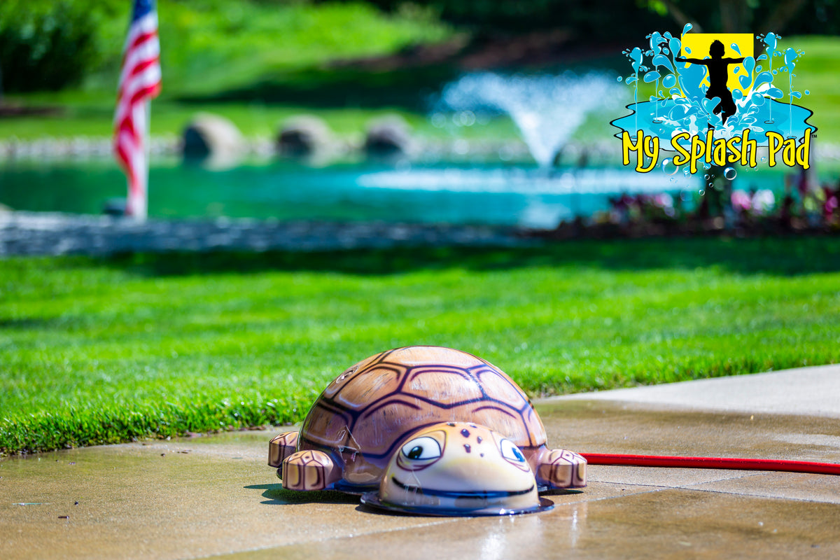 Small Turtle Mobile Splash Pad water play feature with brown shell and playful face, spraying water for kids’ outdoor fun.