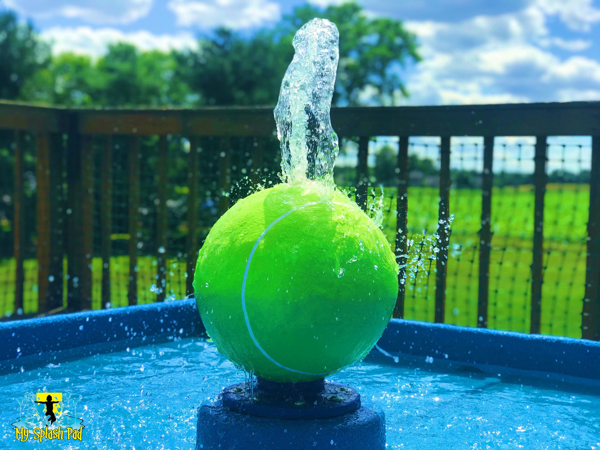 Tennis Ball Portable Water Play Feature by My Splash Pad with green tennis ball fountain spraying water upward in backyard setting.